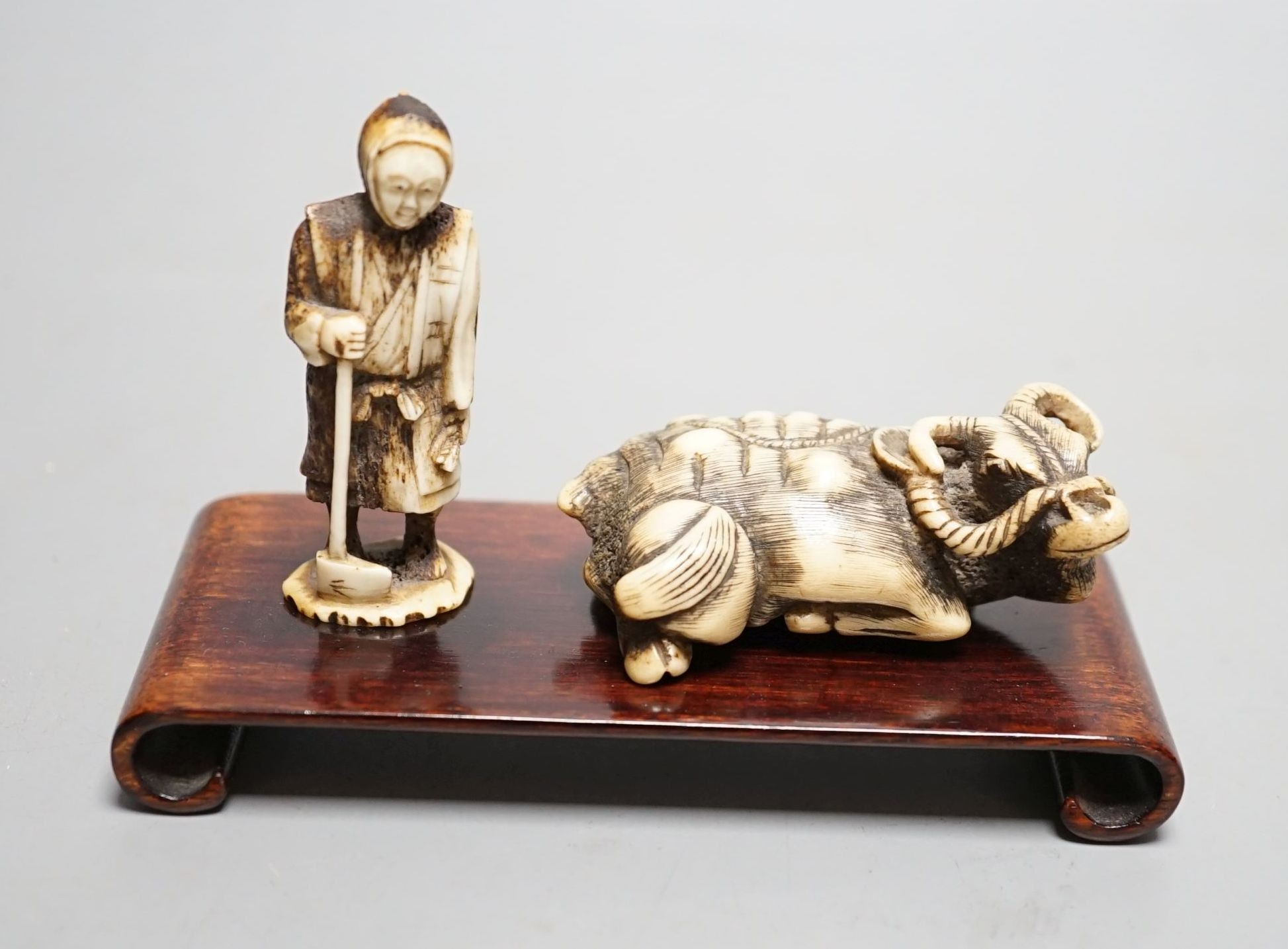 Two Japanese stag antler carvings - a Tomotada style ox netsuke, 7cm long, and a lady, 6.5cm tall, (2)